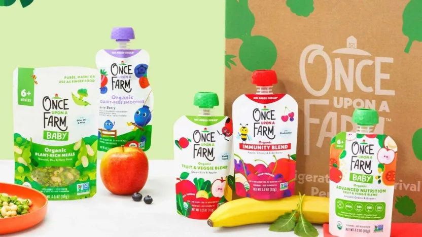 Once Upon A Farm organic baby food pouches in front of a branded paper bag